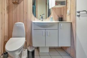 a bathroom with a toilet and a sink and a mirror at 13346-Hojby-Digevaenget-8 in Højby