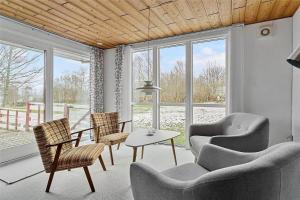 a living room with chairs and a table and windows at LF14221-Roslev-Astrup-Vig-81 in Roslev