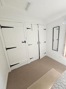 a bedroom with white walls and white doors at Yederick Barn in Sawdon