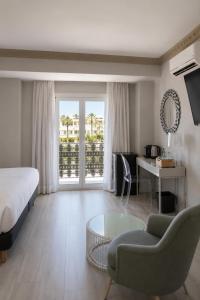 a bedroom with a bed and a couch and a table at Boutique Hotel B51 in Marbella