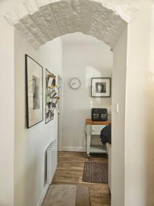 a hallway with white walls and a table and a clock at Yederick Barn in Sawdon