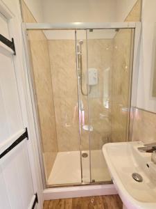 a shower with a glass door next to a sink at Yederick Barn in Sawdon +17 photos