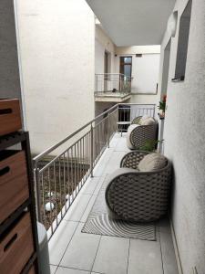 a balcony with two chairs and a railing at Stylish central apartment in Trenčín