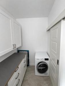 a kitchen with a washing machine in a white kitchen at Stylish central apartment in Trenčín
