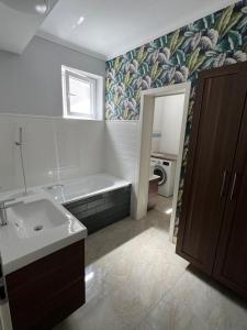 a bathroom with a bath tub and a sink at Stylish central apartment in Trenčín +3 photos