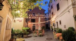 an outdoor patio with tables and chairs and lights at 3 bedroom Apartman Izolana in Izola