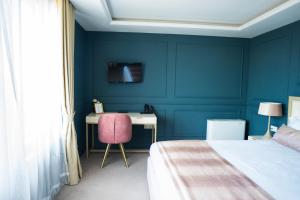 ein blaues Schlafzimmer mit Bett und Schreibtisch in der Unterkunft Monte Vedetta in Sliven