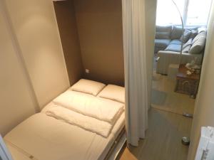 Kleines Zimmer mit zwei weißen Betten. in der Unterkunft Studio Appartement Van Bunnenplein in Knokke-Heist