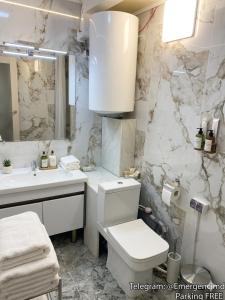 a white bathroom with a toilet and a sink at 31 August 1989 N 59 Hotel apart in Chişinău