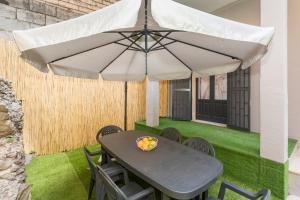 a table and chairs under an umbrella on a lawn at Etnamia Art in Paterno