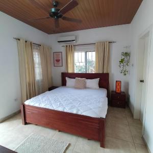 a bedroom with a large bed with a ceiling fan at Nortram Homes - Adenta in Apenkwa