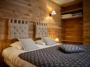a bedroom with a large bed with wooden walls at Clos De La Gourmandière, Maison d'hôtes & Restaurant in Saint-Lothain +67 photos