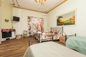 a bedroom with two beds and a painting on the wall at Etnamia Art in Paterno