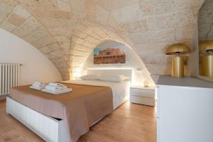 a bedroom with a bed and a stone wall at Al Vecchio Cinema Martano in Martano +24 photos