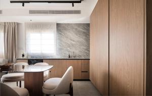 a kitchen with white chairs and a table and a counter at 2BR Balcony High Floor - Dizengoff Square View - MAMAD D80 in Tel Aviv +10 photos