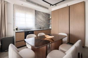 a kitchen with a table and chairs and a counter at 2BR Balcony High Floor - Dizengoff Square View - MAMAD D80 in Tel Aviv