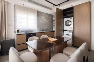 a kitchen with a table and some chairs and a sink at 2BR Balcony High Floor - Dizengoff Square View - MAMAD D80 in Tel Aviv