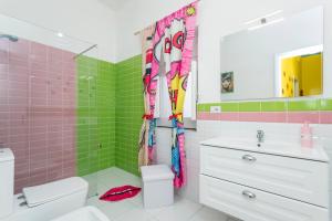 a bathroom with pink and green tiles at Etnamia Art in Paterno +37 photos