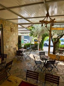 a patio with tables and chairs and a stone wall at Rozafa Sunset in Shkodër