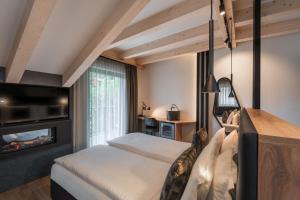 a bedroom with a bed and a fireplace at Hotel Madonnina Resort And Wellness in Soraga +125 photos