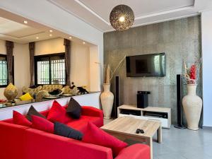 a living room with a red couch and a tv at Atlas View Luxury Villa in Ourika
