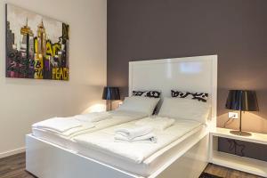 a white bed in a room with two lamps at Priuli Luxury Rooms in Split