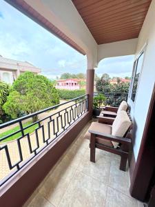 a balcony with two chairs sitting on a balcony at Nortram Homes - Adenta in Apenkwa
