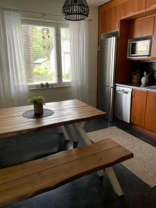 a kitchen with a wooden table and a refrigerator at Yyterin Meriheinä in Pori