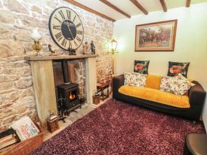 a living room with a couch and a large clock at The LA'AL Cragg in Kirkby Stephen