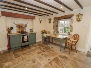 a kitchen with a table and a stove at The LA'AL Cragg in Kirkby Stephen