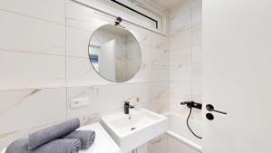 a white bathroom with a sink and a mirror at Candy 3 in Trnava +8 photos