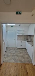 an empty kitchen with white cabinets and a tile floor at Pod Vinicí in Mikulov