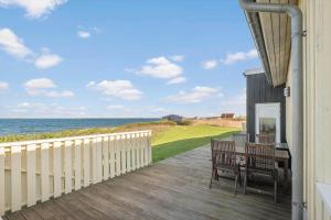 a deck with a table and chairs and the ocean at LF15113-Farso-Strandvejen-12-B in Farsø
