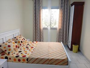 a bedroom with a bed with polka dot sheets and a window at Amidez Apparts in Zalom