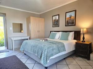 a bedroom with a bed and a table and a mirror at Piketberg Guesthouse in Piketberg