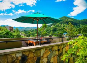 a green umbrella sitting on top of a table at Ever Breeze Ella Hotel in Ella