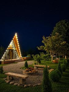 a house with a bench in the yard at night at Cozy Cottage Martvili in Martvili