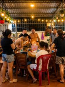 a group of people standing around a table with a birthday cake at Pham's Homestay in Île de Trà Cổ