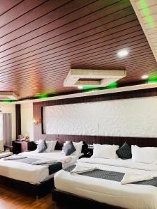 a row of three beds in a room at Hotel La Gowri, Coorg in Madikeri +85 photos