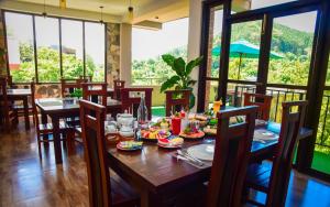 a dining room with a table with food on it at Ever Breeze Ella Hotel in Ella