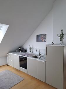 a kitchen with white cabinets and a sink at Zum Nussbaum Wohnung Walnuss 86 qm 2 Schlafzimmer alles neu renoviert in Gerstetten +12 photos