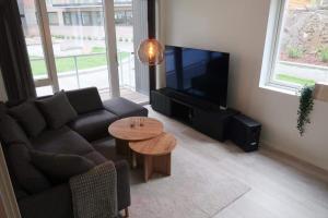 a living room with a couch and a tv and a table at Modern Apartment Bergen Centrum in Bergen