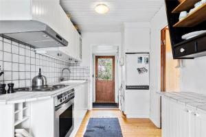 a kitchen with white appliances and a wooden floor at 16615-Farevejle-Alfestien-10 in Fårevejle +6 photos