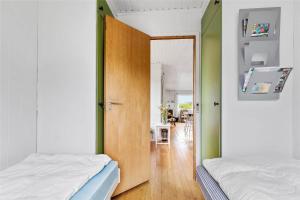 a bedroom with two beds and a door with a mirror at 16615-Farevejle-Alfestien-10 in Fårevejle