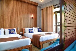 a hotel room with two beds and a window at Ever Breeze Ella Hotel in Ella