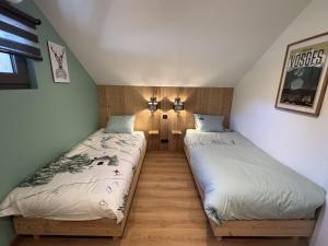 two twin beds in a room with two lamps at Le Petit Nid Gerardmer in Gérardmer