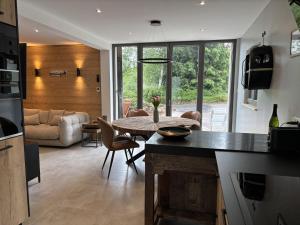 a kitchen and living room with a table and a couch at Le Petit Nid Gerardmer in Gérardmer
