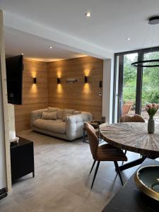 a living room with a couch and a table at Le Petit Nid Gerardmer in Gérardmer