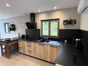 a kitchen with a black counter top and a window at Le Petit Nid Gerardmer in Gérardmer +12 photos