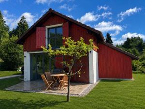 a red and white barn with a table and chairs at Le Petit Nid Gerardmer in Gérardmer